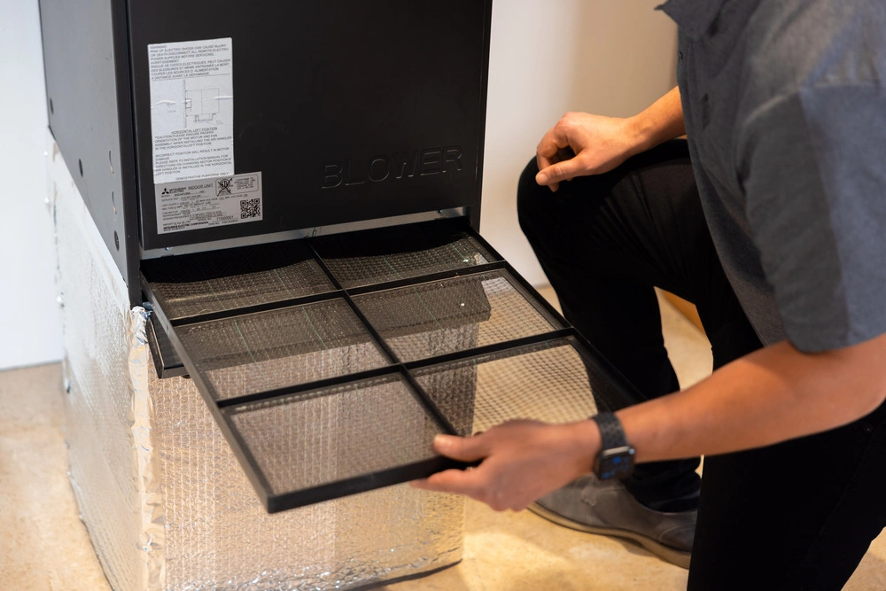 Technician servicing a furnace filter