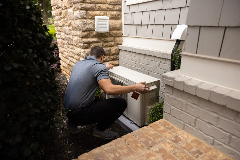 HVAC technician servicing an outdoor AC unit